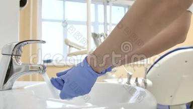 戴着医用手套的牙医下班前洗手。